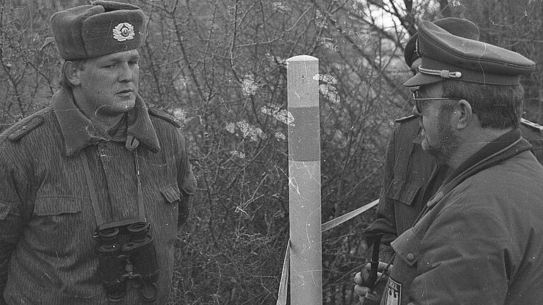 Beamte des Zolls im Gespräch mit einem Soldaten der nationalen Volksarmee der DDR.