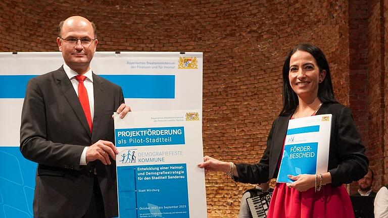 Finanz- und Heimatminister Albert Füracker übergibt den Förderbescheie im Rahmen des Pilotprogramms 'Demografiefeste Kommune' an Sozialreferentin Hülya Düber für den Stadtteil Sanderau. Finanz- und Heimatminister Albert Füracker übergibt den Förderbescheie im Rahmen des Pilotprogramms 'Demografiefeste Kommune' an Sozialreferentin Hülya Düber für den Stadtteil Sanderau.