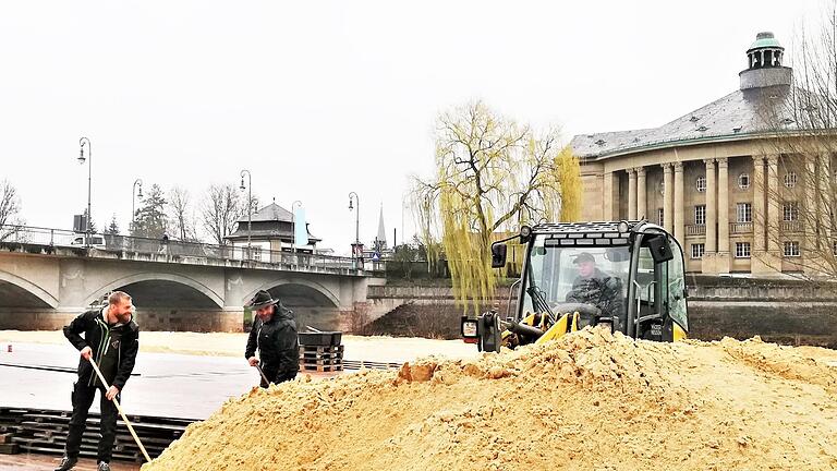 Einen Bagger brauchen die Stadtstrand-Betreiber Johannes (links) und Florian Griebel zur Verteilung der 180 Tonnen Quarzsand auf 1 500 Quadratmetern Strandfläche. - Einen Bagger brauchen die Stadtstrand-Betreiber Johannes (links) und Florian Griebel zur Verteilung der 180 Tonnen Quarzsand auf 1 500 Quadratmetern Strandfläche. Einen Bagger brauchen die Stadtstrand-Betreiber Johannes (links) und Florian Griebel zur Verteilung der 180 Tonnen Quarzsand auf 1 500 Quadratmetern Strandfläche. - Einen Bagger brauchen die Stadtstrand-Betreiber Johannes (links) und Florian Griebel zur Verteilung der 180 Tonnen Quarzsand auf 1 500 Quadratmetern Strandfläche.