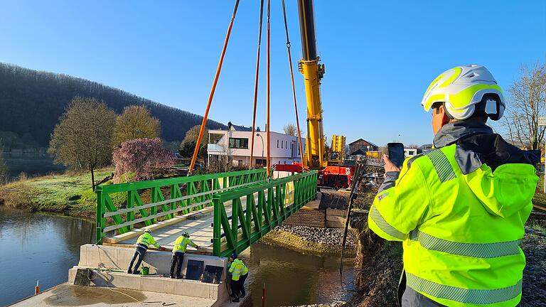 Um die Behelfsbrücke parallel zur früheren Bahnbrücke über die Mündung des Hafenlohrbachs in Position zu bringen, wurde ein 500-Tonnen-Kran benötigt. Um die Behelfsbrücke parallel zur früheren Bahnbrücke über die Mündung des Hafenlohrbachs in Position zu bringen, wurde ein 500-Tonnen-Kran benötigt.