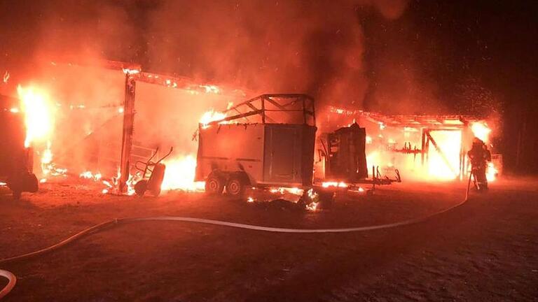 Feuer und Rauch, dazwischen schemenhaft Feuerwehrleute, die gegen den Brand ankämpfen. Die Belastung durch giftige Stoffe ist hoch. Feuer und Rauch, dazwischen schemenhaft Feuerwehrleute, die gegen den Brand ankämpfen. Die Belastung durch giftige Stoffe ist hoch.