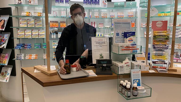 Mit Maske hinter dem Schutzglas: Auch der Apotheker Dr. Ralf Köber muss sich in der Corona-Krise neuen Herausforderungen stellen. Mit Maske hinter dem Schutzglas: Auch der Apotheker Dr. Ralf Köber muss sich in der Corona-Krise neuen Herausforderungen stellen.