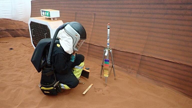Simulierter Einsatz auf dem Mars - Ein CHAPEA-Besatzungsmitglied nimmt an einem simulierten 'Marswalk' im Inneren der 1.200 Quadratmeter großen Anlage teil. Der Platz ist mit rotem Sand gefüllt, um die Marslandschaft zu imitieren. Simulierter Einsatz auf dem Mars - Ein CHAPEA-Besatzungsmitglied nimmt an einem simulierten 'Marswalk' im Inneren der 1.200 Quadratmeter großen Anlage teil. Der Platz ist mit rotem Sand gefüllt, um die Marslandschaft zu imitieren.