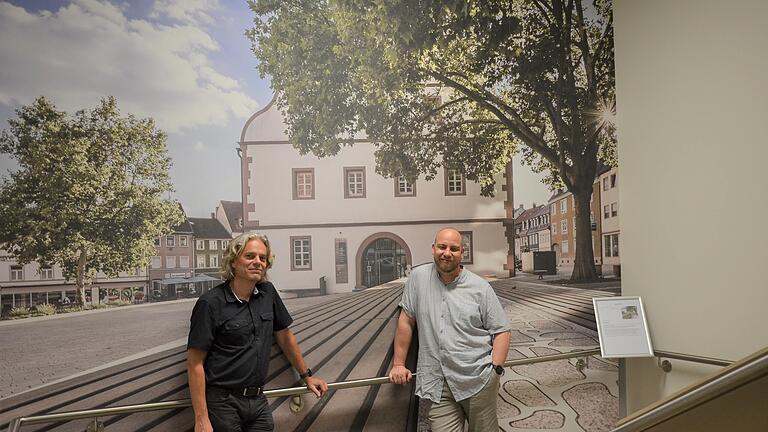 Die beiden Fotografen Dr. Jürgen Wilbert und André Gibson vor einem Bild aus dem neugestaltenden Treppenhaus.