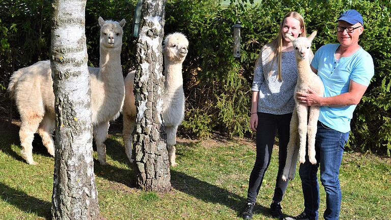 Freuen sich über Nachwuchs bei den Grabfeld-Alpakas: Halter Michael Hippold mit der kleinen Luna auf dem Arm und seine Nichte Pia Weikert.