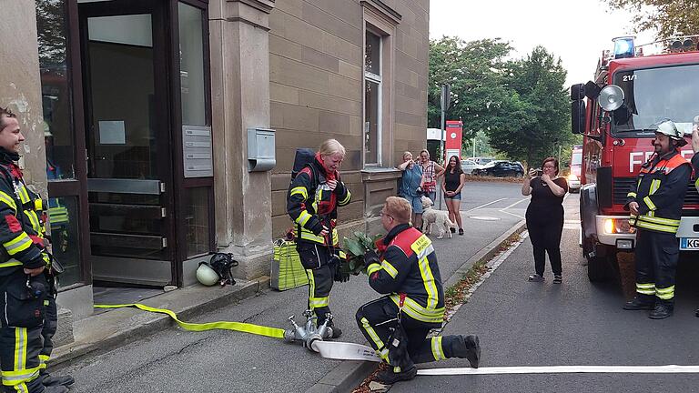 Mike Daum macht Katharina Wolf nach einer Scheinübung der Freiwilligen Feuerwehr im Münnerstädter Bahnhof einen Heiratsantrag. Einige Mitglieder waren eingeweiht, andere nicht. Auch einige Verwandte waren dazu gekommen. Foto: Daniel Röhlinger       -  Mike Daum macht Katharina Wolf nach einer Scheinübung der Freiwilligen Feuerwehr im Münnerstädter Bahnhof einen Heiratsantrag. Einige Mitglieder waren eingeweiht, andere nicht. Auch einige Verwandte waren dazu gekommen. Foto: Daniel Röhlinger