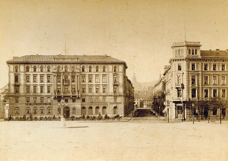 Blick vom Bahnhofsvorplatz in die Kaiserstraße im Jahr 1898. Links steht das repräsentative Palais der Bauunternehmung Buchner, das den 16. März 1945 weitgehend überstand, aber Anfang der 1970er Jahre zugunsten des Modehauses C&A abgerissen wurde. Blick vom Bahnhofsvorplatz in die Kaiserstraße im Jahr 1898. Links steht das repräsentative Palais der Bauunternehmung Buchner, das den 16. März 1945 weitgehend überstand, aber Anfang der 1970er Jahre zugunsten des Modehauses C&A abgerissen wurde.