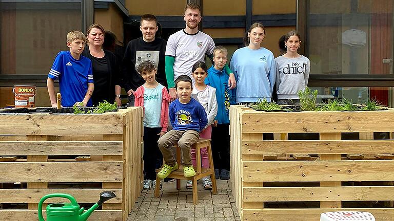 Zwei Kräuterhochbeete für das Kinderheim in Geesdorf: Nach getaner Arbeit blicken die Auszubildenden von Kräuter Mix zusammen mit den Jungen und Mädchen zufrieden auf ihr Werk.