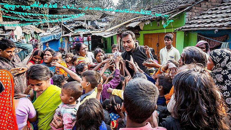 Sozialarbeiter Fahim verteilt mit Simone und Stefan Bauer Kleidung, die die beiden für die Kinder im Shalimar Slum, Kalkutta, mitgebracht hatten.