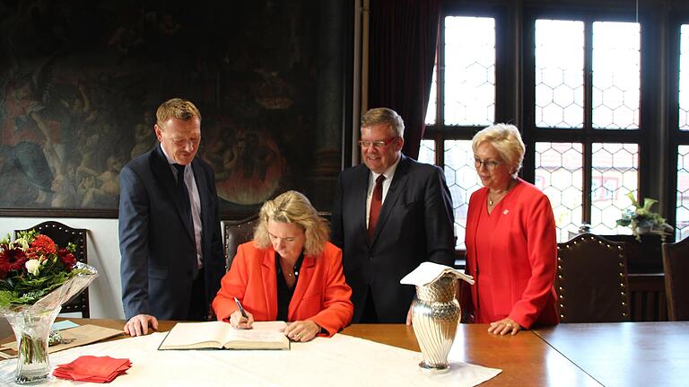 Kerstin Schreyer, Staatsministerin für Familie, Arbeit und Soziales in Bayern, trägt sich anlässlich der Eröffnung des Familienstützpunkts Ochsenfurt ins Goldene Buch der Stadt ein. Von links: Bürgermeister Peter Juks, Kerstin Schreyer, Landtagsabgeordneter Volkmar Halbleib, Anke Klaus, Vorsitzende des SkF Würzburg e.V.  Foto: Catharina Hettiger