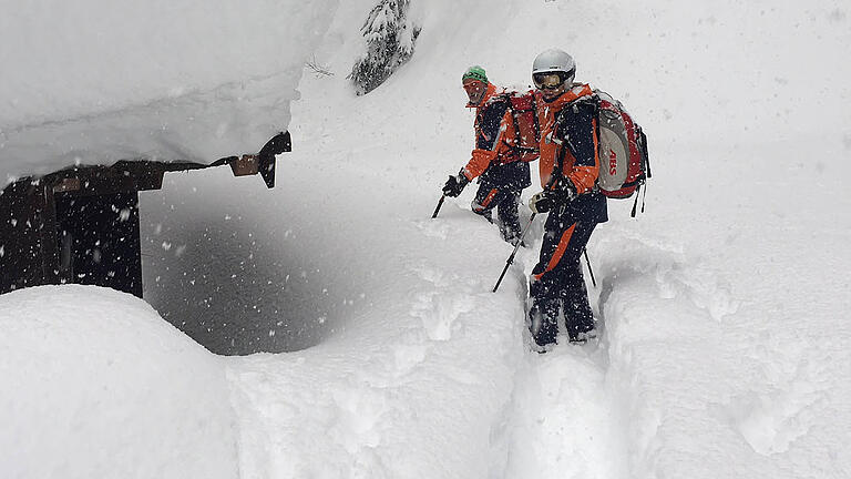 Snowboarder aus Würzburg gerettet       -  06.01.2019, Österreich, Zell Am See: Dieses von der Bergrettung zur Verfügung gestellte Foto zeigt Retter im Schnee. Nach einer Nacht im Freien ist in Österreich ein deutscher Snowboarder unverletzt gerettet worden. Er habe in einer selbstgebauten Schneehöhle unter einem Baum übernachtet, berichtete der 23-Jährige aus Würzburg den Rettern. Zuvor habe er aufgrund schlechter Sichtverhältnisse unfreiwillig die Piste verfehlt und sei immer mehr in unwegsames Gelände gekommen. Foto: Unbekannt/BERGRETTUNG/dpa