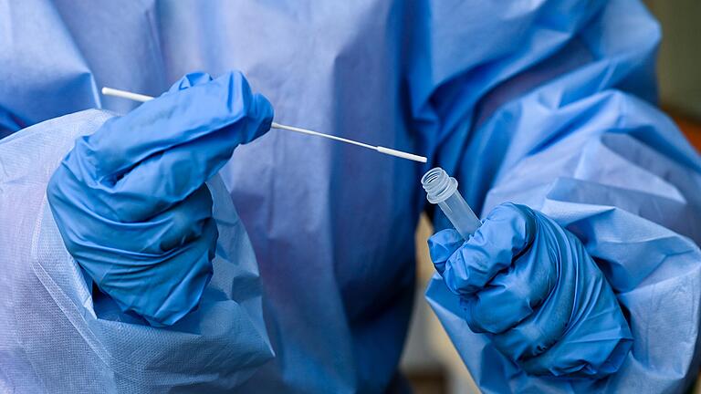 Eine Krankenschwester eines mobilen Test-Teams des Deutschen Roten Kreuzes (DRK) steckt während einer Corona-Testung ein Teststäbchen in die Flüssigkeit eines Schnelltests. Eine Krankenschwester eines mobilen Test-Teams des Deutschen Roten Kreuzes (DRK) steckt während einer Corona-Testung ein Teststäbchen in die Flüssigkeit eines Schnelltests.