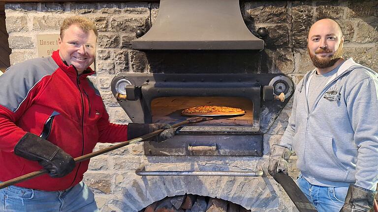 Wenn in Burghausen Backofenfest-Zeit herrscht, muss das ganze Dorf mithelfen. Oliver (links) und Christian Brendel schauen gerade, ob die Pizza schon fertig ist.