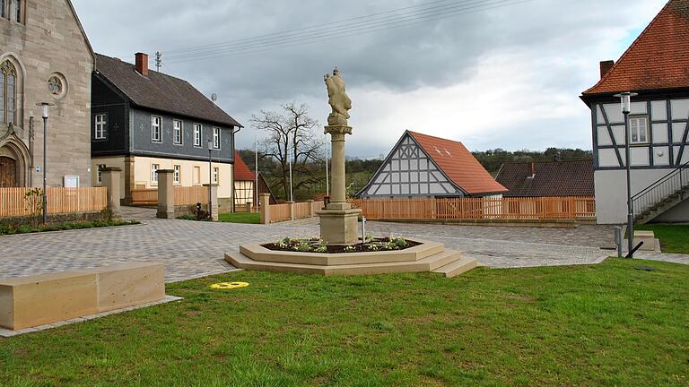 Gelungene Dorferneuerung in Herbstadt, aber der Steinquader (links im Bild) muss noch sitztechnisch aufgebessert werden.