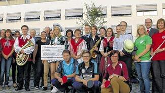 Sparkasse kann nicht nur rot, sondern auch bunt. Zur Spendenübergabe mit den Vorständen Angelika Zotter (Zweite von links) und Georg Straub (rechts) kamen Mitarbeiterinnen und Mitarbeiter in Tracht, Sport- und Musikantenoutfit und sogar im Gardekostüm.