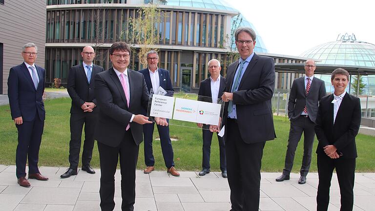 Referenzklasse in der Herzmedizin: Die Siemens-Medizin-Sparte 'Siemens Heathineers' hat den Campus zum Referenz-Standort ernannt. Bei der Übergabe der dazugehörigen Plakette freuten sich (von links) Prof. Dr. Anno Diegeler (Chefarzt Kardiochirurgie), Priv.-Doz. Lukas Lehmkuhl (Chefarzt diagnostische Radiologie), Dr. Bernd Ohnesorge (Leiter Europa, Mittlerer Osten und Afrika, Siemens Healthineers), Rhön-Medizin-Vorstand Prof. Dr. Bernd Griewing, Prof. Dr. Sebastian Kerber (Chefarzt Kardiologie I), Campus-Direktor Jochen Bocklet, Prof. Dr. Thomas Deneke (Chefarzt Kardiologie II), Doris Pommi (Leitung Cardiovascular Care, Siemens Healthineers).