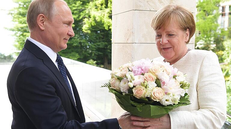 Kanzlerin Merkel trifft Präsident Putin       -  Präsident Wladimir Putin begrüßt Bundeskanzlerin Angela Merkel in Sotschi.