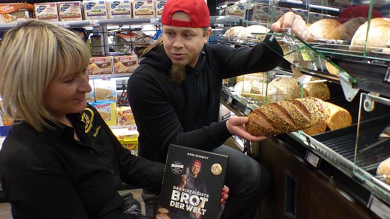 Axel Schmitt ist nicht nur Bäcker, sondern auch Buchautor. Hier stellt er sein Werk Mitarbeiterin Katharina Pfriem (Edeka) vor.