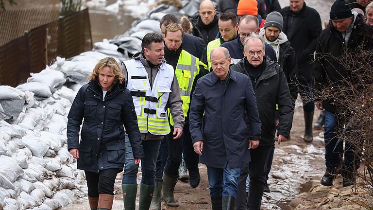 Olaf Scholz.jpeg       -  Bundeskanzler Olaf Scholz (vorne rechts) trägt bei seinem Besuch im Hochwassergebiet in Sangerhausen Gummistiefel.