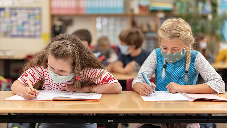 Zwei Schülerinnen der Steinbachtal-Grundschule tragen Masken im Unterricht.&nbsp;