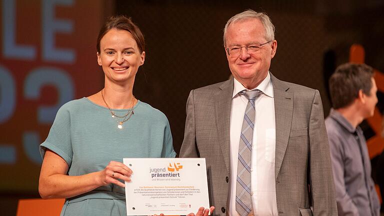 Jennifer Röll und Schulleiter Hartmut Beck nehmen die Auszeichnung als 'Jugend Präsentiert-Schule' entgegen.