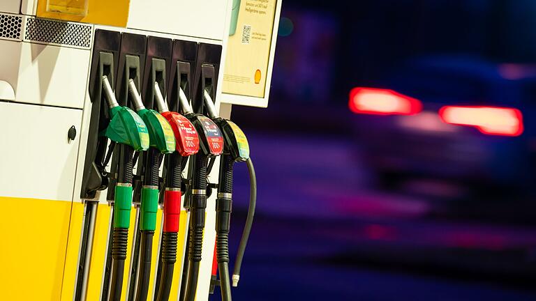 Zapfsäule - Ein Auto fährt am frühen Morgen an der Zapfsäule einer Tankstelle vorbei. Zapfsäule - Ein Auto fährt am frühen Morgen an der Zapfsäule einer Tankstelle vorbei.