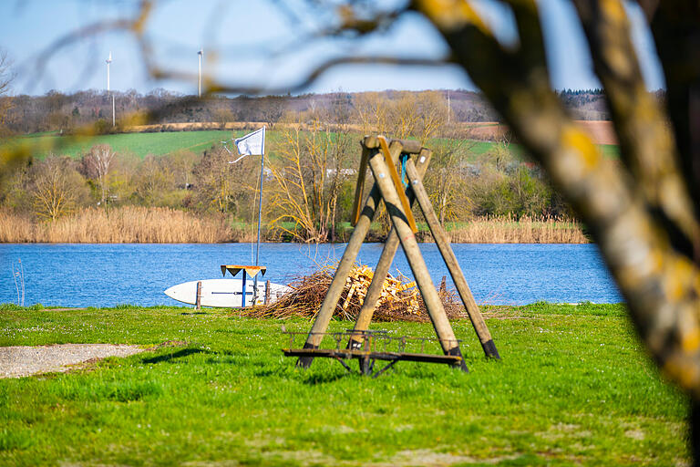 Am Horhäuser See zwischen Wonfurt und Horhausen steht ein Surfbrett bereit zum Surfen. Zum Baden ist es aktuell aber noch zu kalt.