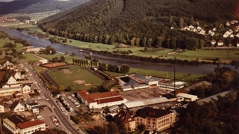 Der Sportplatz des TSV Lohr Anfang der 1960er-Jahre. Das Luftbild zeigt die mittlerweile verschwundene Firma Knecht im Vordergrund, die alte Stadthalle und die alte Sport- und Festhalle. Links an der Jahnstraße sind die Firma Goßmann mit der Shell-Tankstelle (heute Kupsch-Markt), Baustoff-Friedel (jetzt Dänisches Bettenlager und Blues Corner), danach die Aral-Tankstelle und Reifen-Thiele zu sehen.