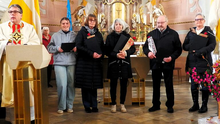 Von Pfarrer Thomas Amrehn und Ortsteamsprecherin Karin Johe-Nickel geehrt für ihren Einsatz für die St.-Aegidius-Gemeinde: Selina Hoffart, Gaby Berchtold, Doris Berchtold, Rudolf Back, Anita Niedermeyer. Im Hintergrund: Ortssprecherin Karin Johe-Nickel.