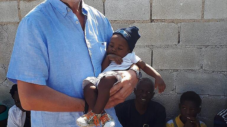 Jürgen Schmitt mit einem kleinen Kind, das in der Krankenstation der Taubertäler Hilfsgemeinschaft auf Haiti erfolgreich behandelt wurde.