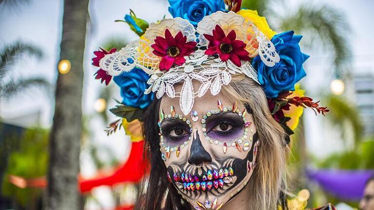 Eine schrill verkleidete Frau beim «Tag der Toten», organisiert von der mexikanischen Gemeinschaft im brasilianischen Sao Paulo. Am «Dia de los Muertos» wird in Mexiko in fröhlicher Atmosphäre der Verstorbenen gedacht. Foto: Cris Faga       -  Am 'Dia de los Muertos' stehen aufwendige Gesichtsbemalungen auf dem Programm.