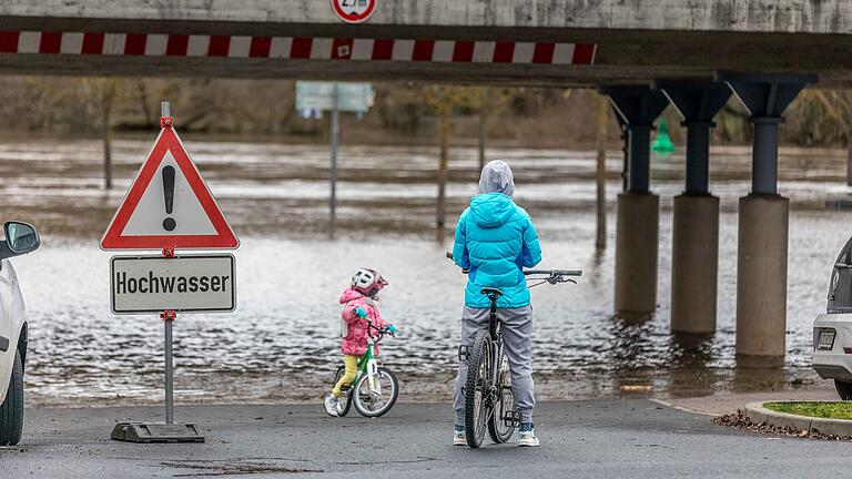 Hochwasser       -  Der Mainpegel steigt und steigt, auch wenn es am 1. Weihnachtsfeiertag aufgehört hat zu regnen. Jetzt aber fließt das Wasser vom Obermain nach. Blick auf die Hochwasserlage in Randersacker (Lkr. Würzburg) am 26.12.23. Der Parkplatz am Main ist geflutet.