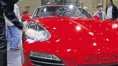 Ein Messemitarbeiter poliert einen ausgestellten Porsche. Bis zum 5. April zeigen knapp 500 Aussteller aus 20 Ländern ihre Neuheiten, wie die Messe mitteilteDPA