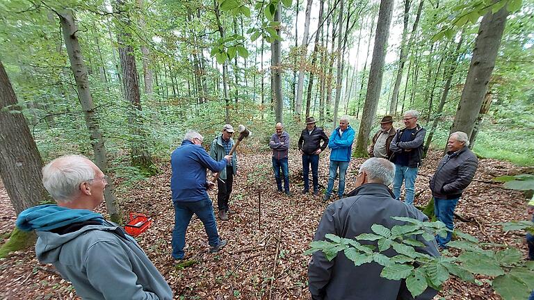 Forstsachverständiger Paul Gerlach (mit Schildkappe) machte den Lindacher und Hambacher Waldbesitzern deutlich, worauf es bei der Waldwertermittlung ankommt. Unter anderem ließ er einen hohlen Stab einschlagen, um eine Bodenprobe zu nehmen.