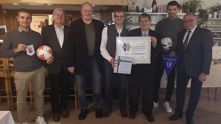 Mit der Goldenen Raute des Bayerischen Fußballverbandes wurde der SV Burgwallbach anlässlich seines 70-jährigen Bestehens ausgezeichnet. Die Ehrung wird für besondere Verdienste in den Bereichen Jugend, Ehrenamt, Breitensport, Gesundheit und Prävention verliehen. Das Bild zeigt (von links) den Vorsitzenden Marcel Mölter, Johann Giglhuber (BLSV), Rainer Lochmüller (BFV), Bruno Kleinhenz (Ehrenamtsbeauftragter des SV Burgwallbach), Klaus Eisenmann (Ehrenamtsbeauftragter des BFV für den Kreis Rhön), Abteilungsleiter Benedikt Floth und Bürgermeister Rudi Zehe.