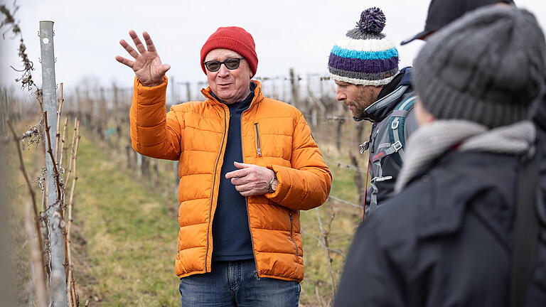 Randersackerer Weinfrühling: Weinbergswanderung       -  14 Menschen nehmen am Samstag (15.03.25) im Rahmen des „Randersackerer Weinfrühlings“ an einer Weinbergswanderung teil. Unter dem Titel „Date mit Franz“ führt der Dozent für Wein- und Genusskultur, Franz Sauer (in der orangenen Jacke), die Interessierten von der Goldenen Badewanne im Ortskern von Randersacker hoch in die Weinlage Lämmerberg. Unterwegs werden verschiedene Weine verkostet.
