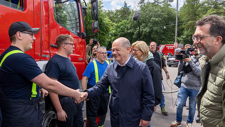 Hochwasser im Saarland - Bundeskanzlerbesuch.jpeg       -  Bundeskanzler Olaf Scholz (Mitte) besucht mit Anke Rehlinger (hinten), saarländische Ministerpräsidentin, im Stadion von Saarbrücken Einsatzkräfte.