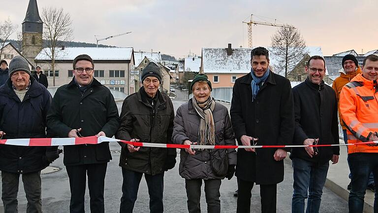 Das Absperrband auf der neuen Tauberbrücke durchschnitten (von links) Christian Meißner (stellvertretender Leiter Straßenbauamt), Ortsvorsteher Hans-Joachim Haas, der älteste Einwohner Elpersheims, Harry Welm, Landrat Christoph Schauder, die Elpersheimer Bürger Helmut Lang und Ruth Stirnkorb, Bürgermeister Nick Schuppert, vom Bauunternehmen Leonhard Weiss Sascha Bißwanger, Philipp Wieland und Michael Hallmeyer sowie Straßenbauamtsleiter Markus Metz.