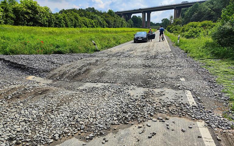 Auf der Straße zwischen Kitzingen und Kaltensondheim hat es aus einem Schotterweg viele Steine auf die Fahrbahn geschwemmt.
