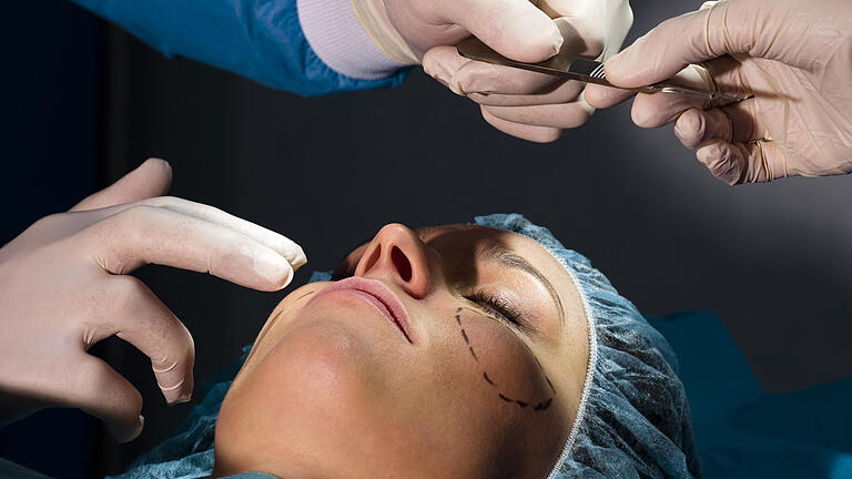 Two surgeons performing plastic surgery on woman - Woman Receiving Plastic Operation Two surgeons performing plastic surgery on woman - Woman Receiving Plastic Operation