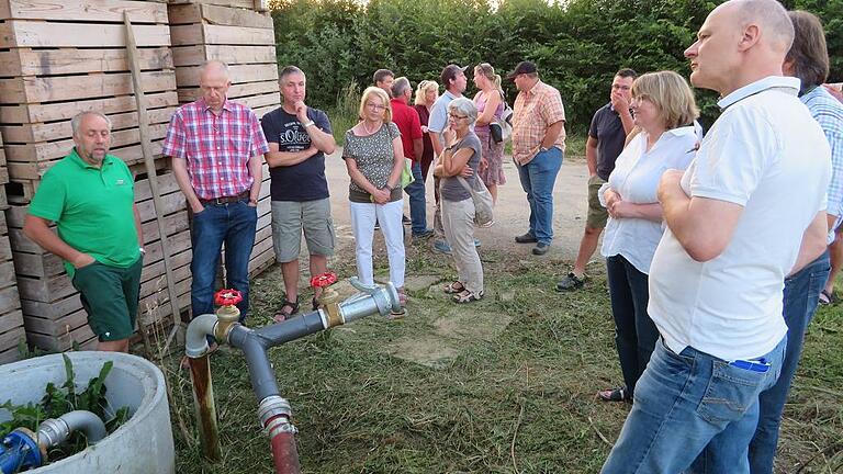 Richard Konrad (links) aus Hausen zeigt Landwirten einen Brunnen, der zu seinem Hof gehört.