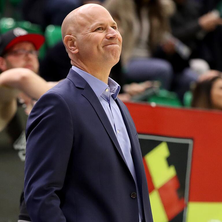 Vor dem Würzburg-Wappen mit leicht verkniffener Miene: Headcoach Denis Wucherer.