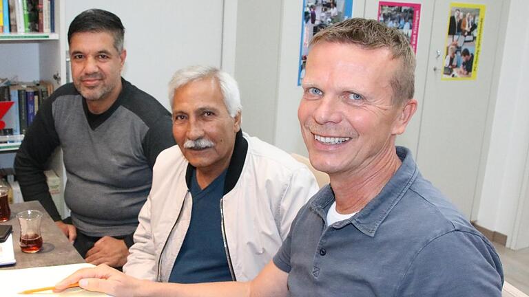 Georg Panzer (rechts) trifft sich jede Woche mit Flüchtlingen und Helfern zum Sprach-Café, gestern saßen unter anderem (von links) Karim Ghafuri und Golahmad Bayat mit am Tisch, um etwas über die deutsche Geschichte zu erfahren. Foto: Ralf Ruppert       -  Georg Panzer (rechts) trifft sich jede Woche mit Flüchtlingen und Helfern zum Sprach-Café, gestern saßen unter anderem (von links) Karim Ghafuri und Golahmad Bayat mit am Tisch, um etwas über die deutsche Geschichte zu erfahren. Foto: Ralf Ruppert