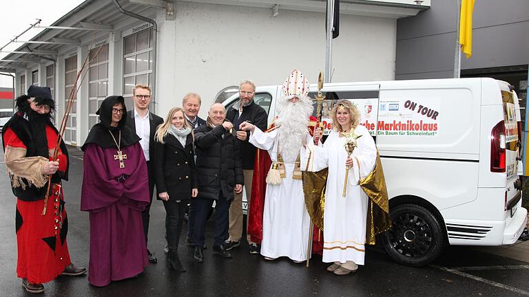 Fahrzeugübergabe zugunsten der Aktion 'Ein Baum für Schweinfurt' bei Auto Löffler mit (von links) Nikolaus-Helfern, Mike und Lisa Löffler, Stefan Labus vom an der Aktion beteiligten Verein Schweinfurter Kindertafel, Robert Löffler, Aktionskoordinator Rüdiger Wolf, sowie dem Fränkischen Marktnikolaus und einem Weihnachtsengel. Fahrzeugübergabe zugunsten der Aktion 'Ein Baum für Schweinfurt' bei Auto Löffler mit (von links) Nikolaus-Helfern, Mike und Lisa Löffler, Stefan Labus vom an der Aktion beteiligten Verein Schweinfurter Kindertafel, Robert Löffler, Aktionskoordinator Rüdiger Wolf, sowie dem Fränkischen Marktnikolaus und einem Weihnachtsengel.