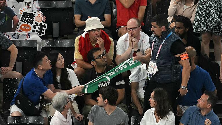 Paris 2024 - Badminton       -  Ein Sicherheitsmann entfernt ein Transparent mit der Aufschrift 'Taiwan' beim Badminton.