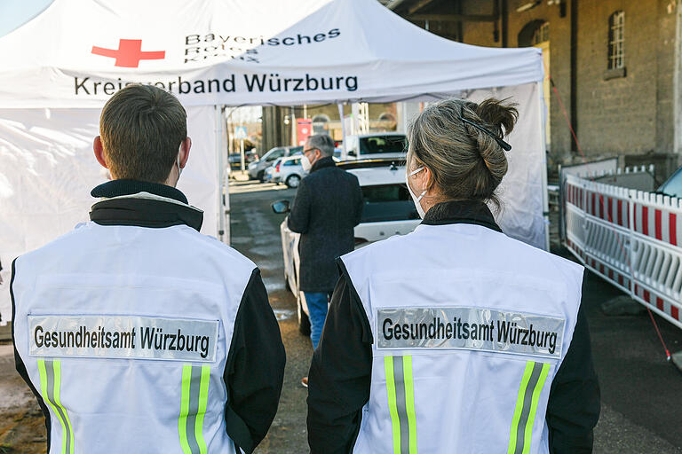 Mitarbeiter des Gesundheitsamtes für Würzburg Stadt und Landkreis erklären an der BRK-Teststrecke am Ochsenfurter Bahnhof, wie eine Teststation richtig zu betreiben ist.