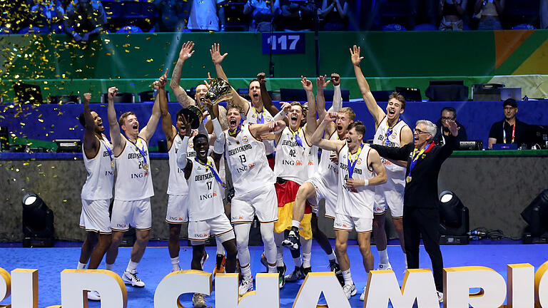 Serbien - Deutschland.jpeg       -  Deutschlands Dennis Schröder (vierter von links) hebt den Pokal bei der Siegerehrung hoch und feiert mit dem Team den WM-Titel. Rechts Bundestrainer Gordon Herbert.