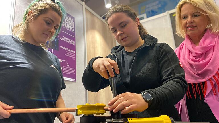 Katharina Barth und Vanessa Kempf zeigen Landrätin Tamara Bischof die Arbeit einer Anlagenmechanikerin.