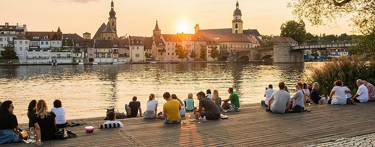 Zum Stadtschoppen kommen nicht nur Touristen; auch die Einheimischen trinken gerne ein Glas am Kitzinger Mainufer.