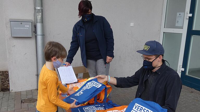 Das 'Spielmobil to go' verteilte in Zeil Überraschungspäckchen mit Spielmaterialien, so wie hier an den siebenjährigen Johannes Hirt. Erzieherin Tamara Gräb (Hinten) und der ehrenamtliche Mitarbeiter Jonas Erickson freuen sich, den Kindern trotz Corona-Einschränkungen dennoch eine Freude machen zu können. Das 'Spielmobil to go' verteilte in Zeil Überraschungspäckchen mit Spielmaterialien, so wie hier an den siebenjährigen Johannes Hirt. Erzieherin Tamara Gräb (Hinten) und der ehrenamtliche Mitarbeiter Jonas Erickson freuen sich, den Kindern trotz Corona-Einschränkungen dennoch eine Freude machen zu können.